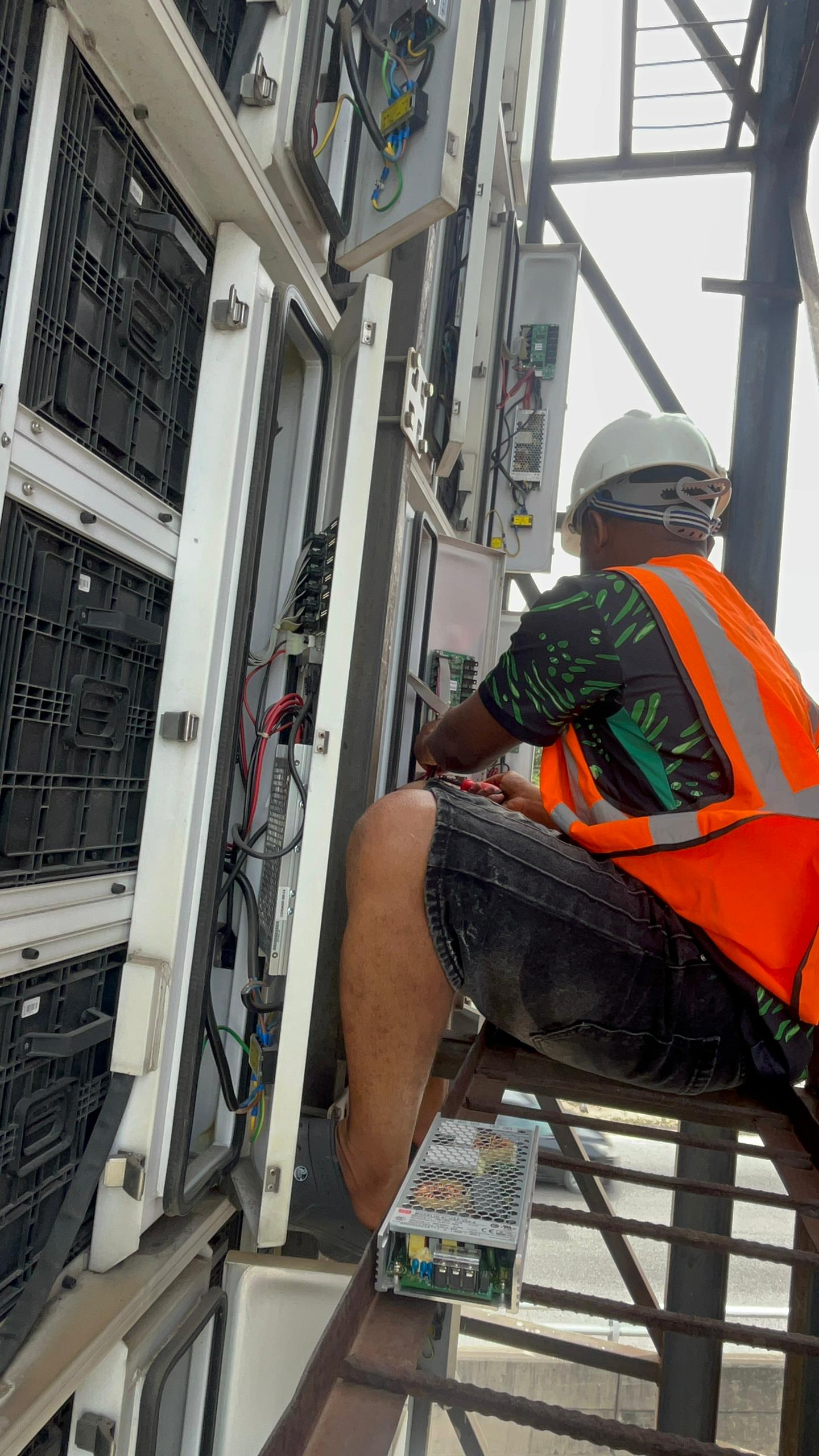 Technician working on LED billboard wiring at height
